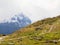 Sharp snowy peaks of Alps mountains above valley full of heavy fog, end of summer