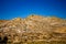 Sharp yellow rocky hills in california in front of a clear blue sky