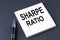 SHARPE RATIO text on the sticker with pen on the black background