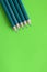 Sharpened pencils leing on green backgrond, top view