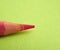 Sharpened pink pencil on a green background
