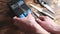 Sharpening a knife on an electric sharpener at home. The man`s hand drives the knife blade between the blue sharpeners, dust flies