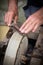 Sharpening knife on old grindstone wheel