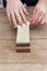 Sharpening the knife with a whetstone on a wooden background. Top view.