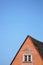 Sharply peaked roof with trompe loeil around window