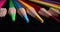 Sharply sharpened multicolored pencils on black background