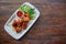 Shashlik, meat cooked on skewers on an open table, in a white plate on a wooden background