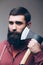 Shaving with axe. Portrait of Confident young bearded man carrying a big axe