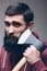 Shaving with axe. Portrait of Confident young bearded man carrying a big axe on shoulder and looking at camera