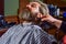 Shaving with electric razor. mature man at barbershop. brutal bearded man at hairdresser. professional barber with male