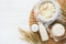 Shavuot jewish holiday celebration. Milk and cheese, ripe wheat and fruits, cream on white wooden background. Dairy products over