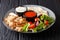 Shawarma bowl with chicken, hummus, fresh vegetables salad and sauce close-up. horizontal