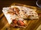 Shawarma pita bread with grilled chicken, shaurma doner, fresh vegetables and cream sauce on a light stone or concrete background