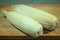 A sheaf of corn in leaves on a wooden board. Two pieces