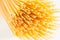Sheaf Italian long yellow spaghetti closeup on white background.