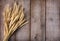 Sheaf of wheat ears on wooden table