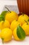 Sheared ripe yellow-orange lemon fruits near the potted citrus plant on the dining table, close-up. Harvesting the indoor growing