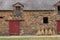 Sheaves of hay are put against the facade of a barn in Saint-Aubin-des-Chateaux (France)