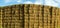 Sheaves of hay stacked into wall on the field in england uk on a sunny day