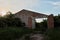 Shed on an abandoned livestock farm. Overgrown ruined building