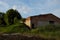 Shed on an abandoned livestock farm. Overgrown ruined building