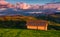 Shed on the grassy hillside in red evening light