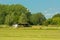 Shed in a meadow with trees under a clear blue sky in Kalkense Meersen nature reserve, Flanders, Belgium.