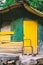 A shed or shack made of corrugated iron painted green and yellow