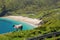 Sheep on a cliff in focus, Keem beach out of focus, Achill island in county Mayo, Ireland, warm sunny day. Clear blue sky and