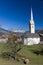 Sheep graze in front of large white church