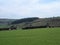 Sheep and new spring lambs grazing in fields surrounded by stone walls and hills in west yorkshire pennine countryside