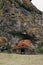 sheep standing in entering to stone and wooden building near spectacular rock