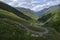 Sheeps crossing the serpentine road. Panorama of mountain valle