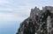 Sheer cliffs with sparse trees and patches of snow over the winter sea