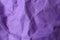 Sheet of crumpled violet paper as background, top view