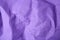 Sheet of crumpled violet paper as background, top view