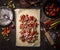 Sheet of dough with sliced rhubarb and strawberries. Strudel pie preparation on rustic kitchen table, top view. Seasonal baking.