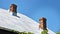 Sheet grey metal roof with two chimneys on a house