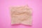 Sheets of crumpled baking paper on pink background, top view