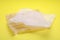 Sheets of crumpled baking paper on yellow background