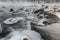 Sheets of ice floes in flowing river Isar near Munich on cold foggy winter day