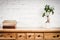 Shelf with books and flower and white wall