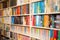 Shelf with books various colors in living room or library blurred bokeh background retro design
