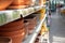 Shelf with empty clay flower pots for sale. Defocus background perspective, brown clay flower pot handmade