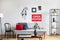 Shelf with green plant in white pot, black jug and candles next to grey couch with pillow and blanket