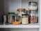 Shelf in the kitchen with various jars of cereals. Glass jars with pasta, lentils, couscous, beans