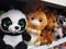 Shelf on the shelf in the children`s store - a lot of soft toys with big eyes panda, hare, bear, raccoon, hare and others.