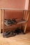 Shelf of shoes and slippers. wooden shoe rack.