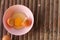 shell with egg and open Eggs in a pink bowl on Bamboo battens. Top view closeup