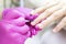 shellac. man in pink gloves puts nail polish